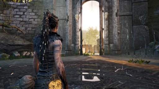 Hellblade: Senua's Sacrifice screenshot - Senua standing before massive doors in ancient ruins