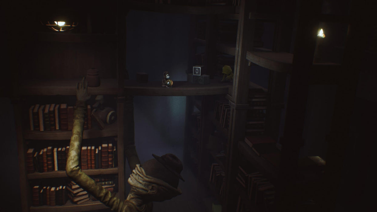 A tense moment from Little Nightmares Complete Edition steam key, where a terrifying, blind creature with long arms reaches for items on shelves, while the protagonist hides in the background on a high bookshelf.