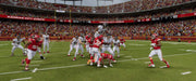 An intense action scene from Madden NFL 24 on EA Play, featuring a high-flying jump by an Atlanta Falcons player over the Kansas City Chiefs defense in the end zone. Buy Madden NFL 24 now at RushGame.co for EA Play and experience this action-packed gameplay.