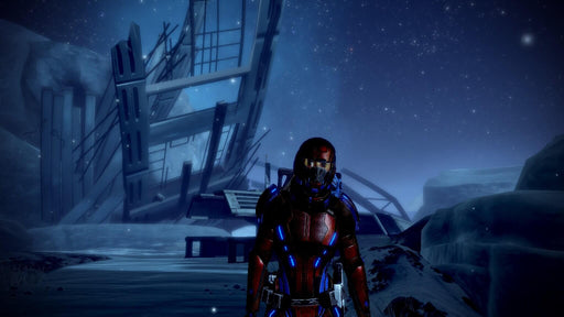 Commander Shepard exploring an icy, mysterious planet with remnants of a destroyed structure under a starry sky. Available on EA Play for PC at RushGame.co