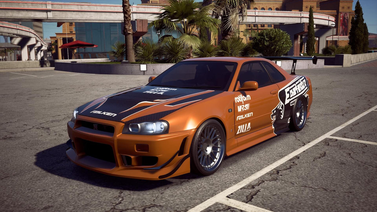 Orange Nissan Skyline GT-R parked under an overpass in Need for Speed Payback Deluxe Edition on Xbox" – Showcasing a heavily modified orange Nissan Skyline GT-R, this image captures a popular racing car ready to take on the streets in Need for Speed Payback Deluxe Edition on Xbox, featuring dynamic city environments