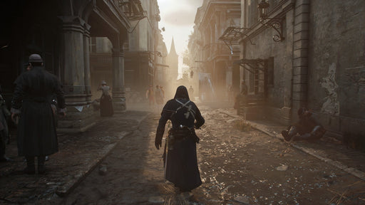 The protagonist, dressed in a dark assassin outfit, walks through a narrow, war-torn street of Paris, illuminated by a hazy golden sunset with citizens in distress. Unlock Assassin's Creed Unity Xbox One key today at RushGame.co and explore the chaos of the French Revolution