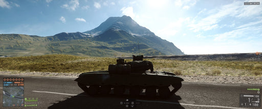 "In-game screenshot from Battlefield 4 on Xbox One, showing a tank positioned on an open road with a mountain landscape in the background under a clear blue sky