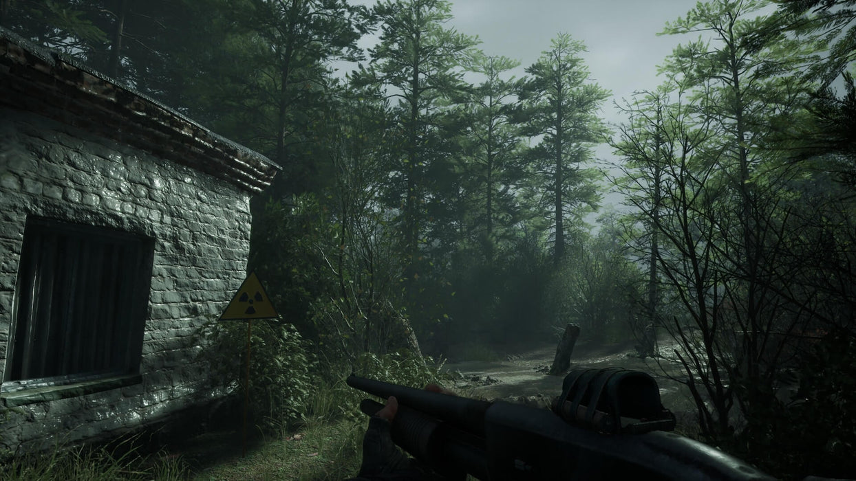 Gameplay screenshot:  A tense in-game moment in Chernobylite, showing a first-person view of a shotgun-wielding survivor approaching an abandoned radiation-marked house deep in the eerie forest. Explore the haunting landscape of Chernobyl with your Chernobylite PC Steam CD Key, available instantly at RushGame.co