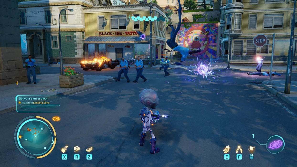 Screenshot from Destroy All Humans! 2 Reprobed showing intense street combat. The alien protagonist, Crypto, engages in battle against human police officers in a small town. Purple energy blasts and telekinetic powers create chaos, with a police car engulfed in flames in the background. Buy Destroy All Humans! 2 Reprobed PC Steam CD Key at RushGame.co