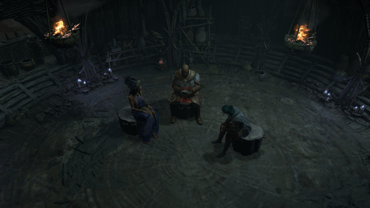 Gameplay screen -  A dimly lit tribal hut interior from Diablo IV, where three characters are seated around a fire-lit circle, engaged in a deep conversation. The atmosphere is dark and foreboding, with wooden structures and mystical artifacts adorning the surroundings. Purchase Diablo IV CD Key for Xbox One & Series X|S at RushGame.co for instant access