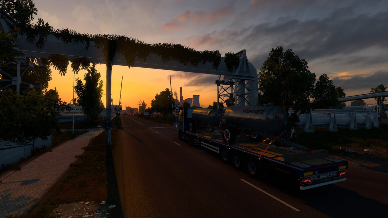 Gameplay screenshot - A detailed sunset scene from Euro Truck Simulator 2, featuring a heavy-duty truck carrying a fuel tanker through an industrial landscape. Experience realistic trucking across Europe with stunning visuals and immersive gameplay. Get your Euro Truck Simulator 2 GOTY Edition PC Steam CD Key at RushGame.co for instant digital delivery