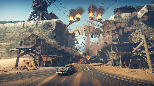 Explosive action in Mad Max Xbox One Key as Max speeds through a crumbling gate with flames and debris flying. Get the best price on Mad Max Xbox One Key at RushGame.co