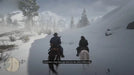 In-game scene from Red Dead Redemption 2 (PC) with two riders navigating a snowy mountain trail. Purchase your RDR2 digital key from RushGame.co and explore breathtaking open-world landscapes