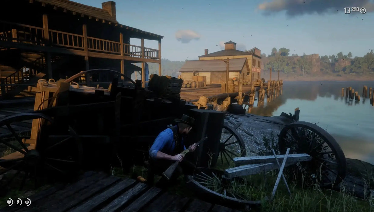 Gameplay image from Red Dead Redemption 2 showing a character crouched with a rifle near a dockside tavern at sunset. Buy this immersive Western adventure now as a digital Xbox CD key on RushGame.co