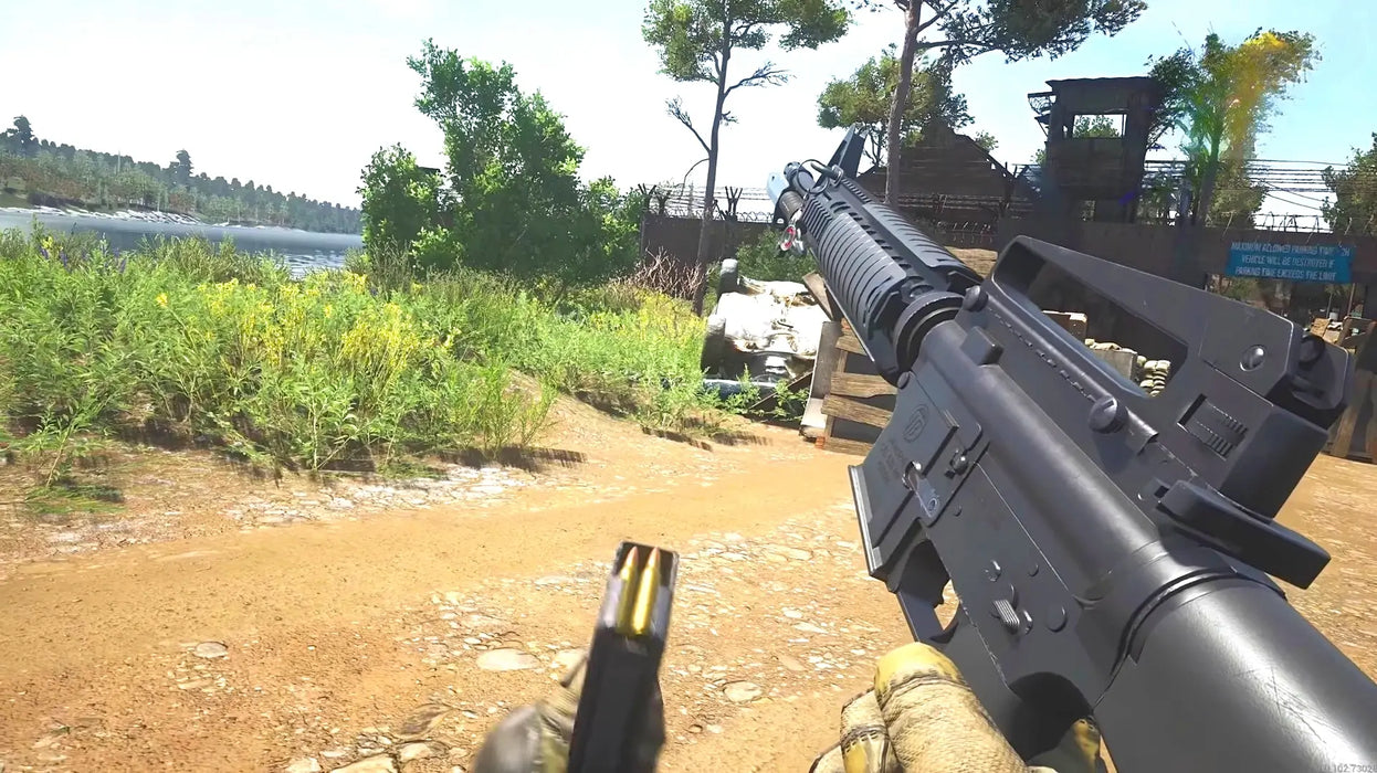 Gameplay image from SCUM Steam Supporter Pack 1 DLC, featuring a first-person view of reloading a rifle near a riverbank with lush greenery and a fortified compound in the distance. Buy your SCUM DLC Steam key today at RushGame.co