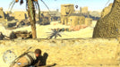 In-game screenshot from Sniper Elite 3 on Steam showing the player character sneaking behind a stone wall in a sunlit North African village. Purchase your Sniper Elite 3 Steam Key at RushGame.co for authentic stealth gameplay and instant delivery!